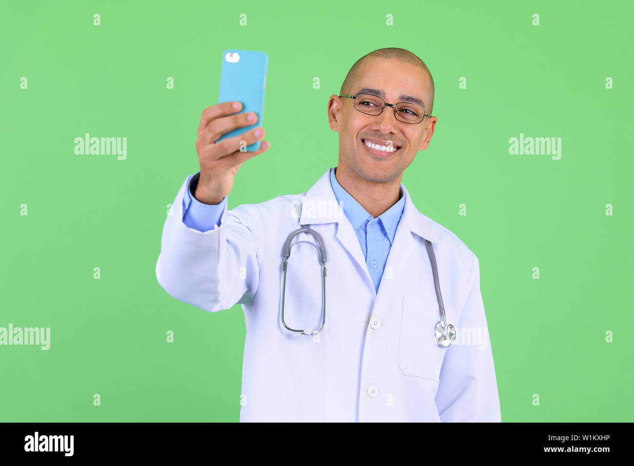 Felice bald multi etnico medico uomo video chiamate con il telefono Foto Stock