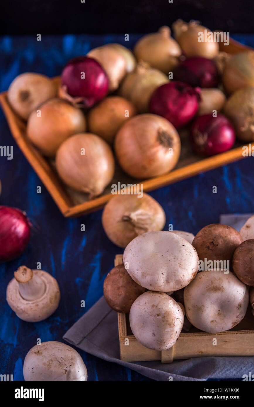 I funghi e le cipolle su uno sfondo blu Foto Stock