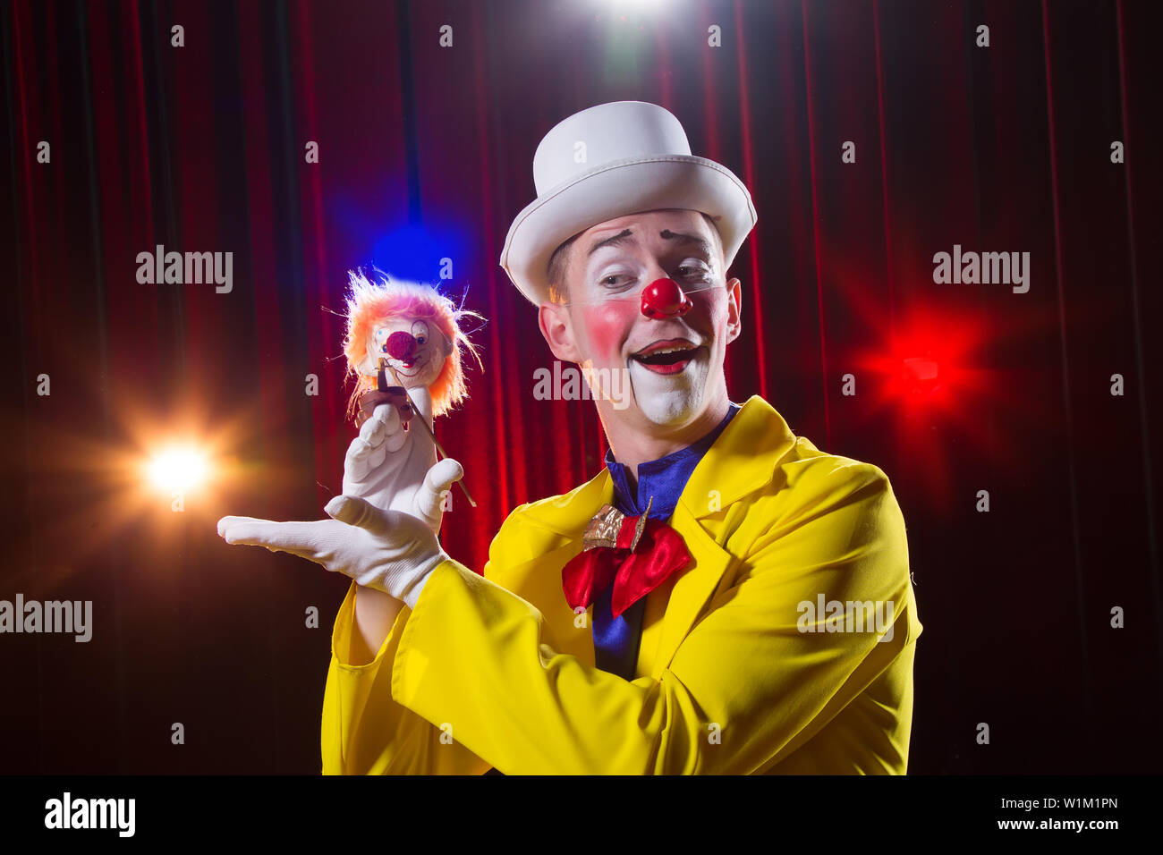 Circus clown esegue il numero. Un uomo in un clown vestito con un giocattolo Foto Stock