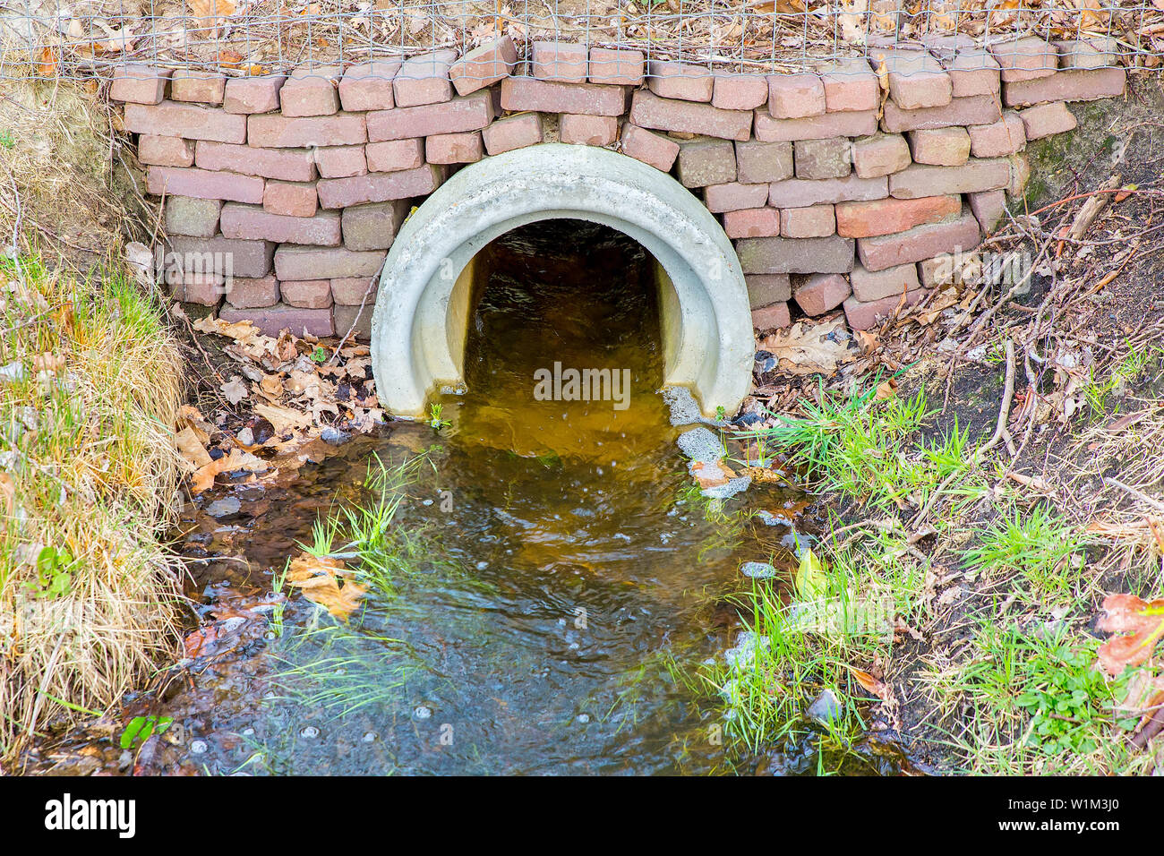 L'acqua che fluisce attraverso il calcestruzzo canale sotterraneo nel fosso europea Foto Stock
