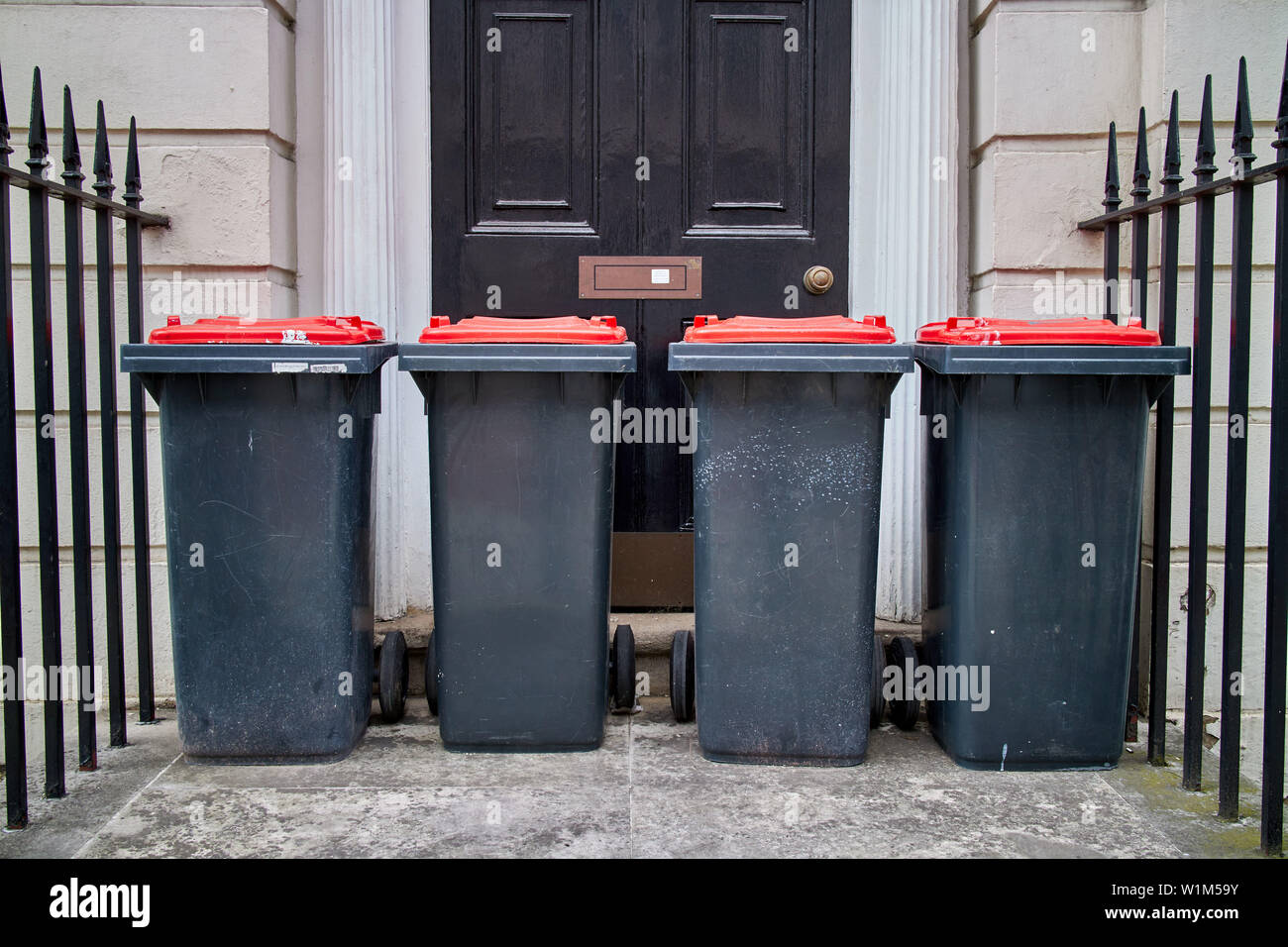 Quattro scomparti wheelie si fermò al di fuori di una porta anteriore. Foto Stock