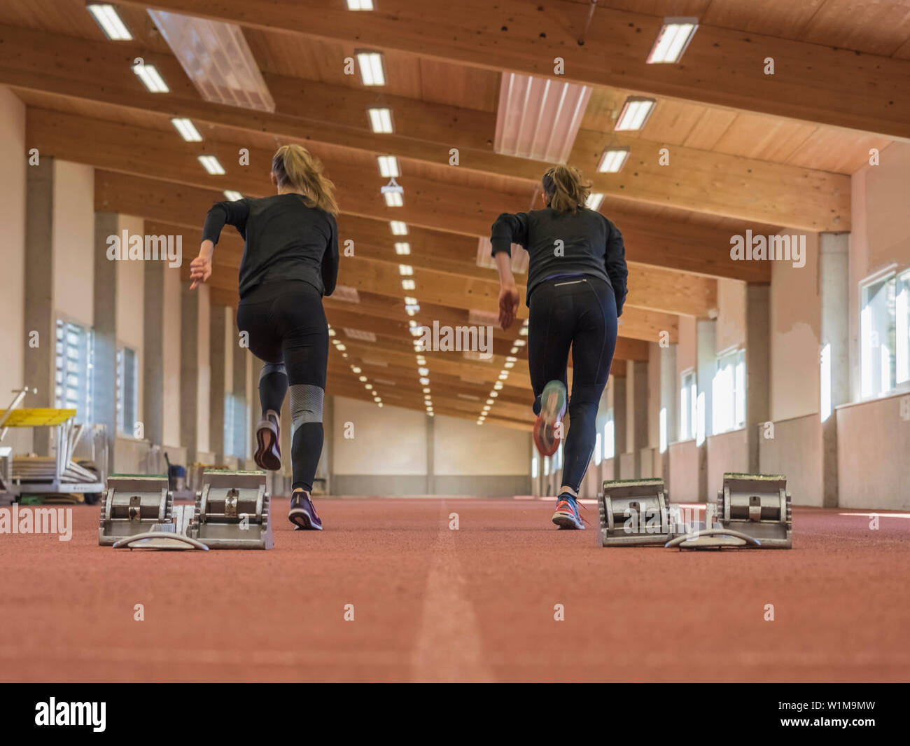 Due donne in esecuzione in sala di atletica sulla pista di tartan, Offenburg, Baden-Württemberg, Germania Foto Stock