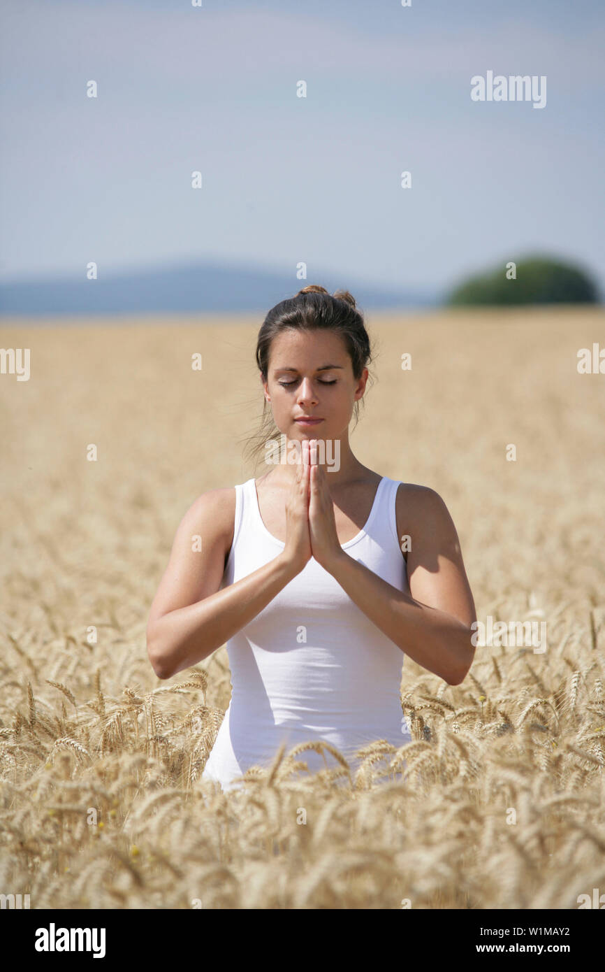 Metà donna adulta meditando in un campo di mais, , la Carinzia, Austria Foto Stock