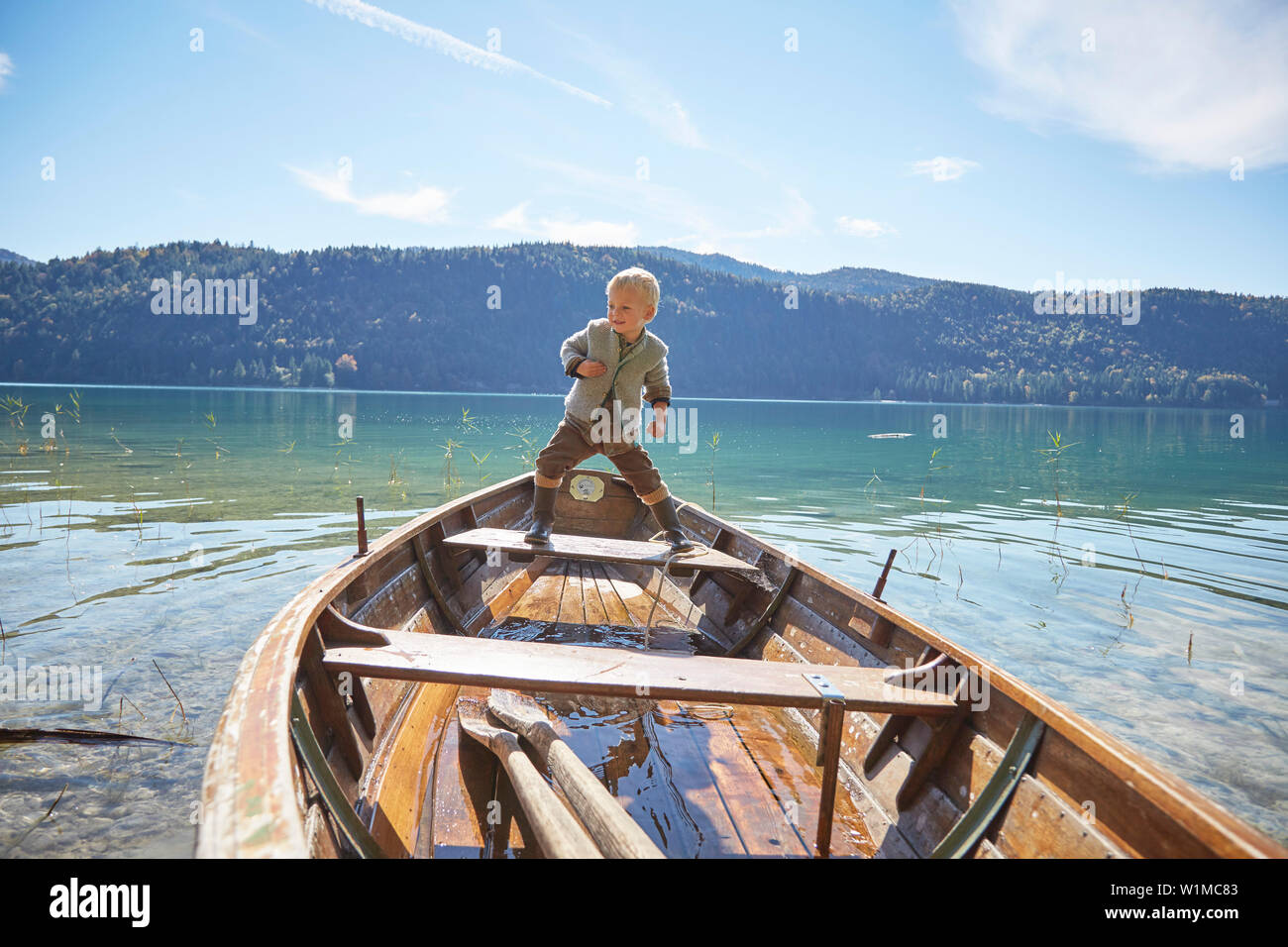 Ragazzo giocando su una barca in un lago Foto Stock
