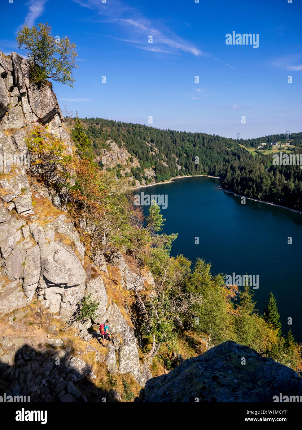 Vista posteriore delle donne escursionista cercando in vista della foresta da Hans roccia sopra bordo Lac Blanc al Rocher Hans, Francia Foto Stock