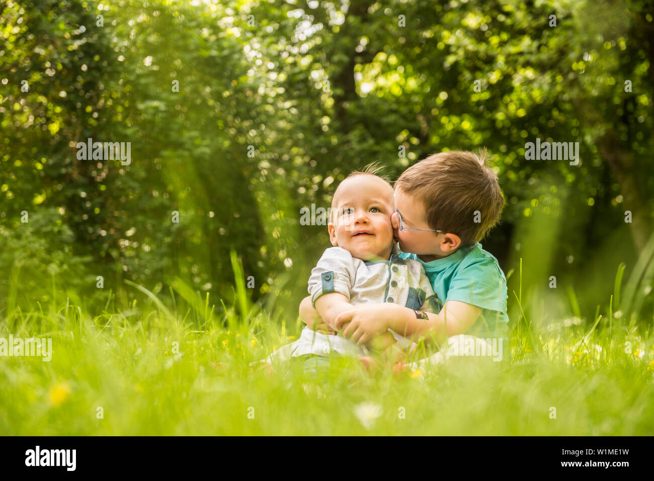 Due piccoli fratelli divertirsi in giardino Foto Stock