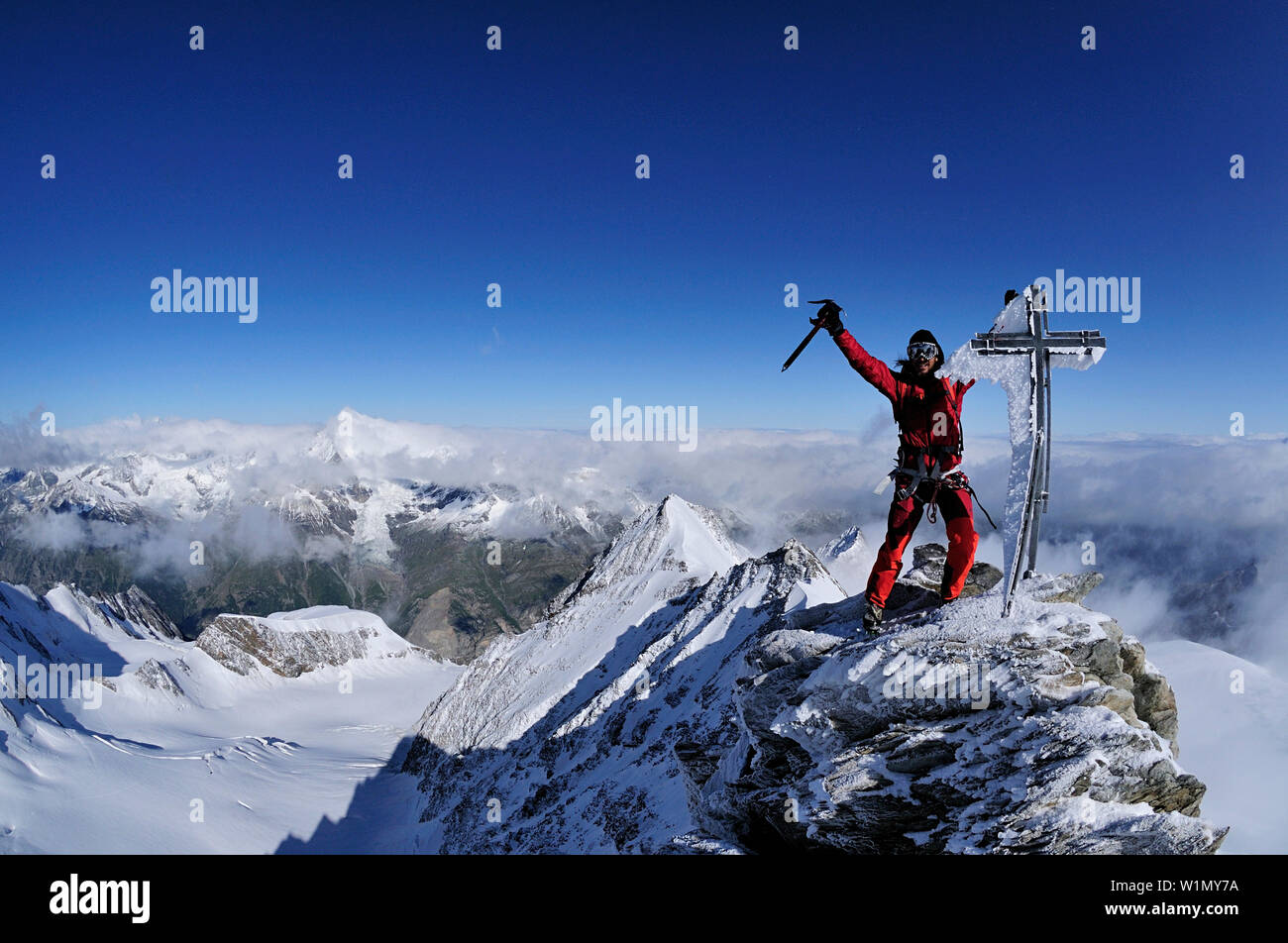 Alpinista al summitcross del Nadelhorn (4327 m), Vallese, Svizzera Foto Stock