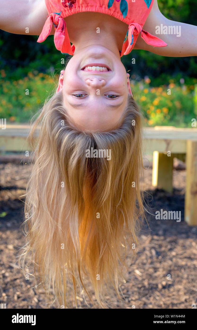 Ragazza appeso a testa in giù al parco Foto Stock