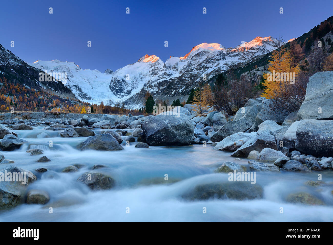 Fiume che scorre attraverso la valle di Morteratsch nella luce del mattino con Bernina gamma in background, Bernina gamma Engadin, Grigioni, Svizzera Foto Stock