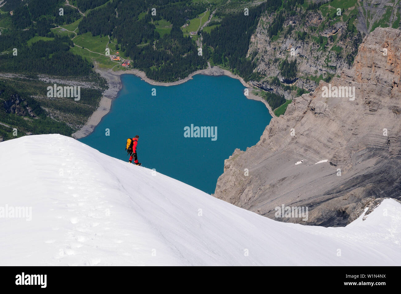 Alpinista durante la discesa del Blümlisalp 3661] (m), Oeschinensee in background, Alpi Bernesi, Svizzera Foto Stock