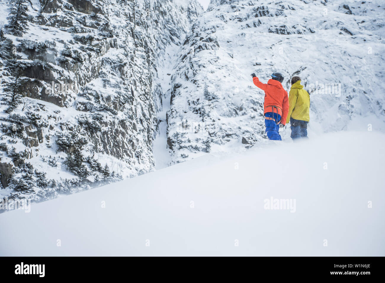 Due giovani sciatori piallare il loro linea successiva in montagna, Andermatt, Uri, Svizzera Foto Stock