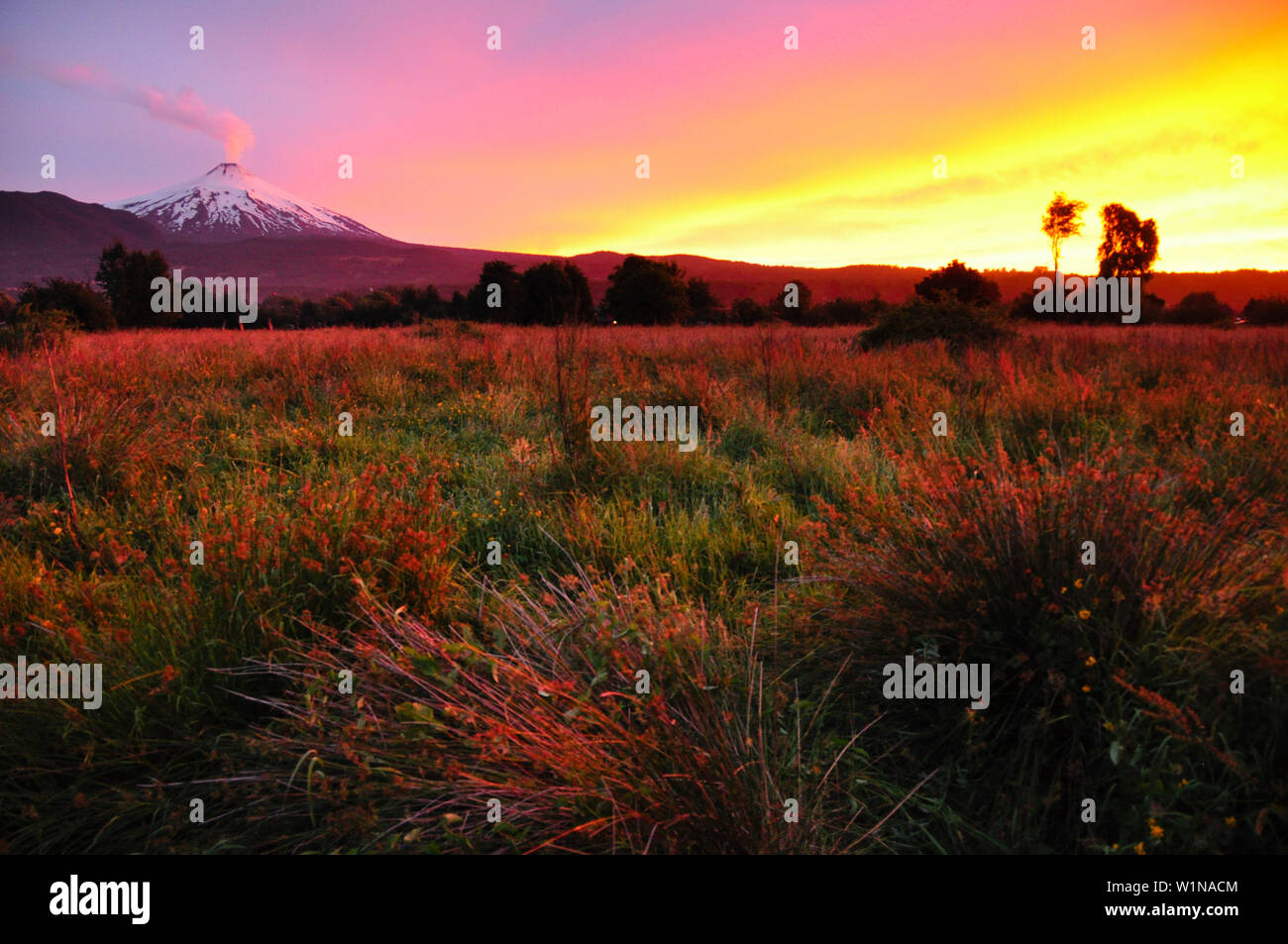 Vulcano Villarrica al tramonto, coperta di neve con fumo signalizing presto esplosione vulcanica e l'eruzione, stratovulcano, tramonto, Parco Nazionale Villarric Foto Stock