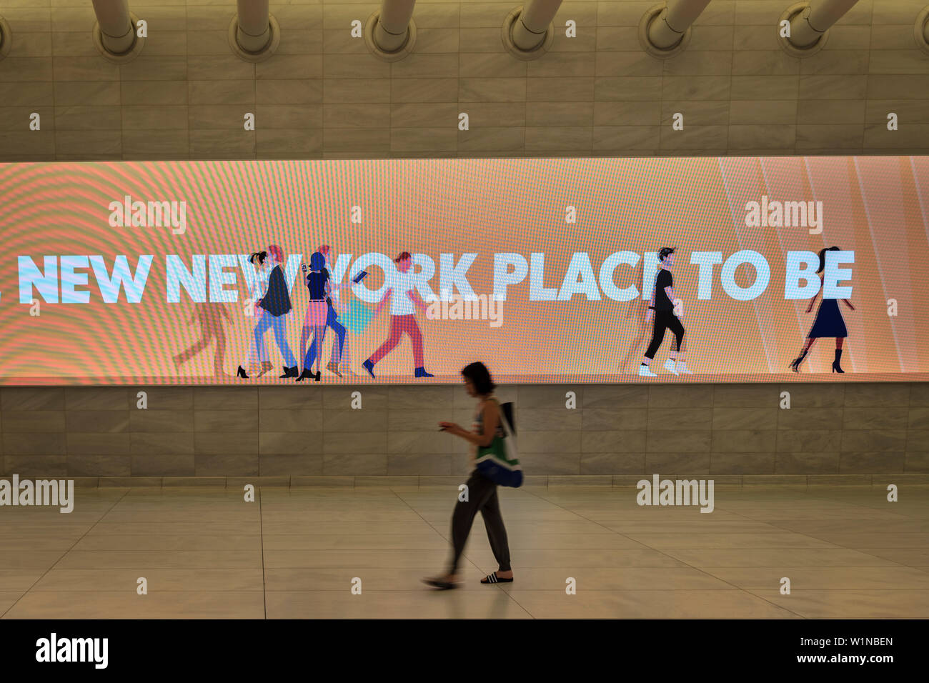 Donna passando un illuminato pubblicità in un corridoio di un occhio mentre guardando il suo telefono cellulare, futuristica Stazione ferroviaria dal famoso architetto Santiago Foto Stock