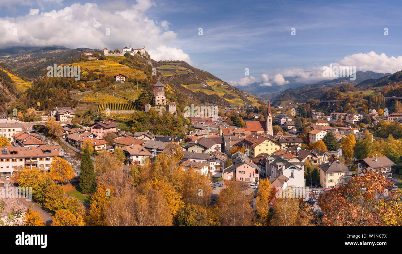Vista panoramica della Valle Isarco sopra i tetti della città chiusa con il castello di Bronzolo e la chiesa parrocchiale in autunno, Alpi Alto Adige, Foto Stock