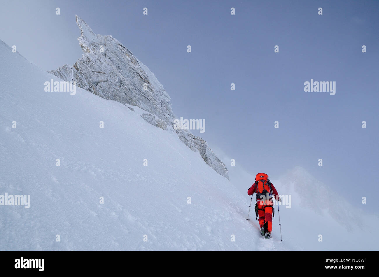 Alpinista durante la tempesta di neve a Nadelhorn (4327 m), Vallese, Svizzera Foto Stock