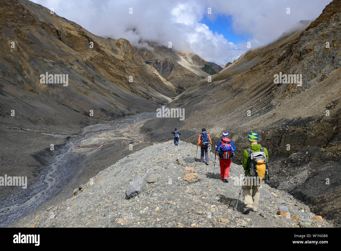 Quattro gli escursionisti, trekking nella valle di yak Kohla sul loro modo da Nar su Teri Tal a Mustang, Nepal, Himalaya, Asia Foto Stock