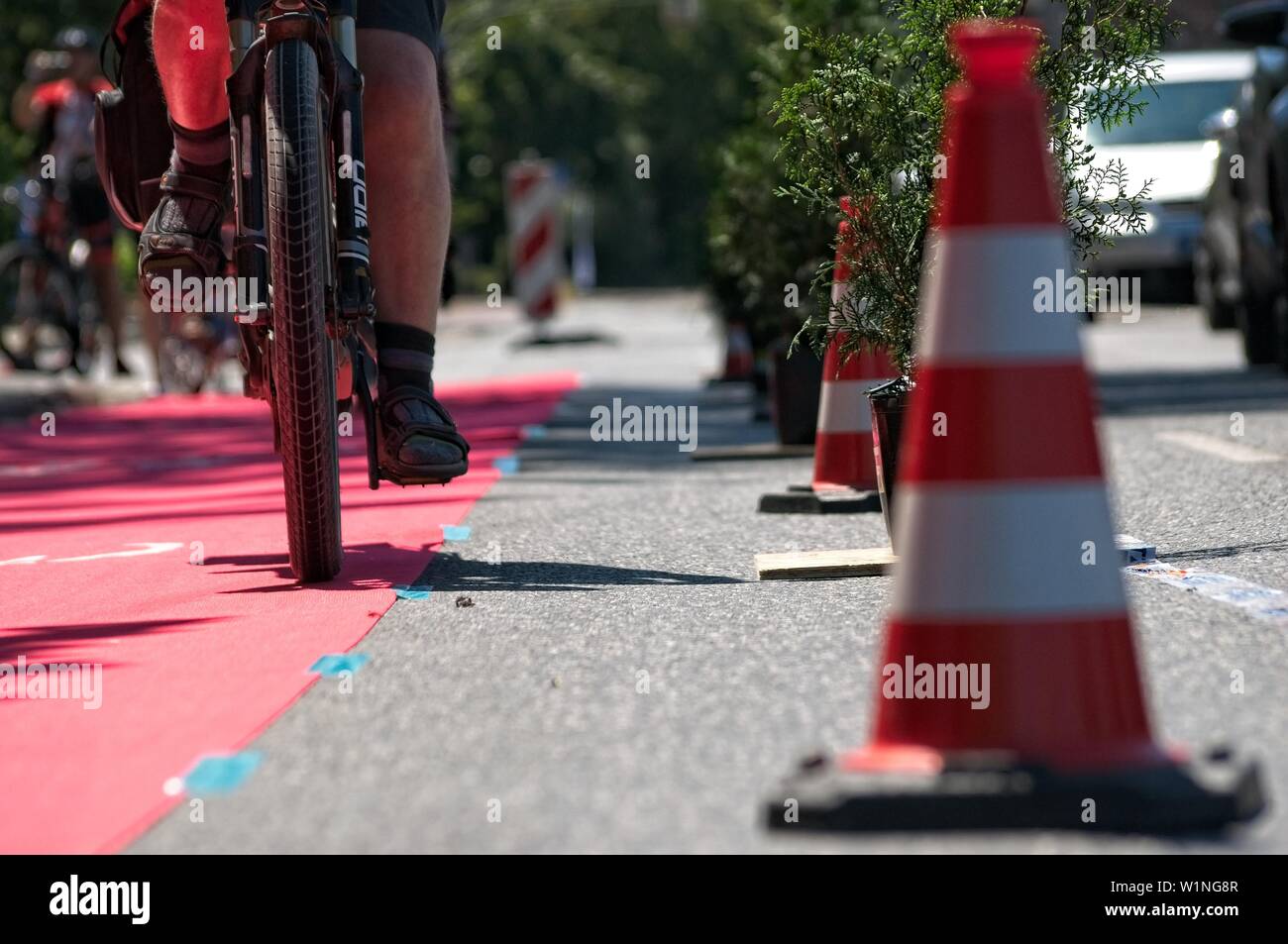 In primo luogo protetto bike lane in Bielefeld il 29 giugno 2019. Mostra un singolo ciclista sul tappeto rosso in prossimità di alcune torri. Foto Stock