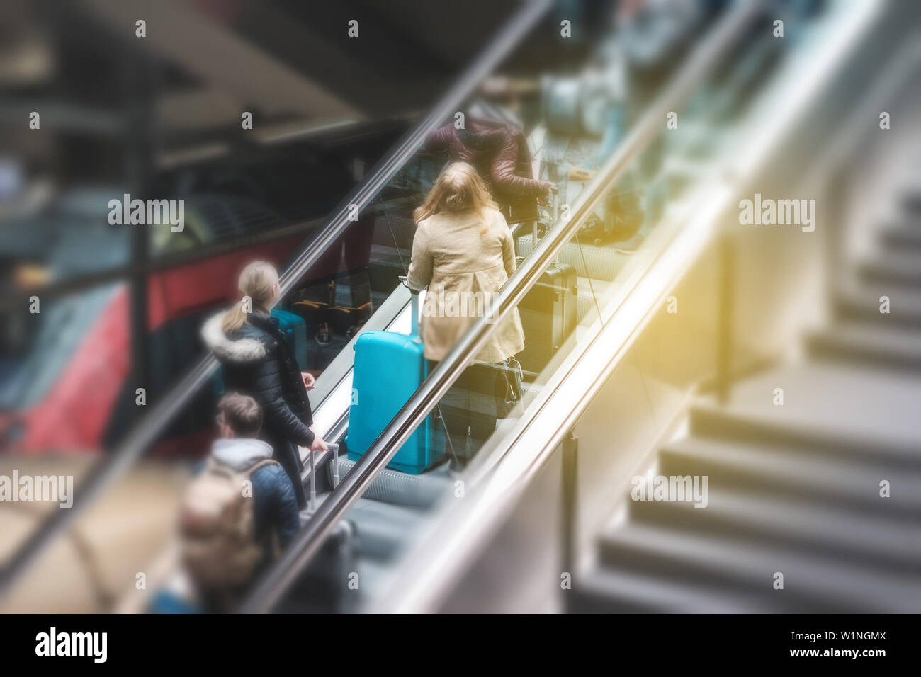 Le persone sulla scala mobile in una stazione ferroviaria, il concetto di viaggio sfocatura del movimento Foto Stock