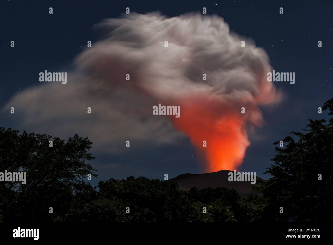 Vista su una grande colonna di cenere del vulcano attivo Yasur sotto la luna piena. La nube di cenere è arrossata dalla lava e esposto alla luce di Foto Stock