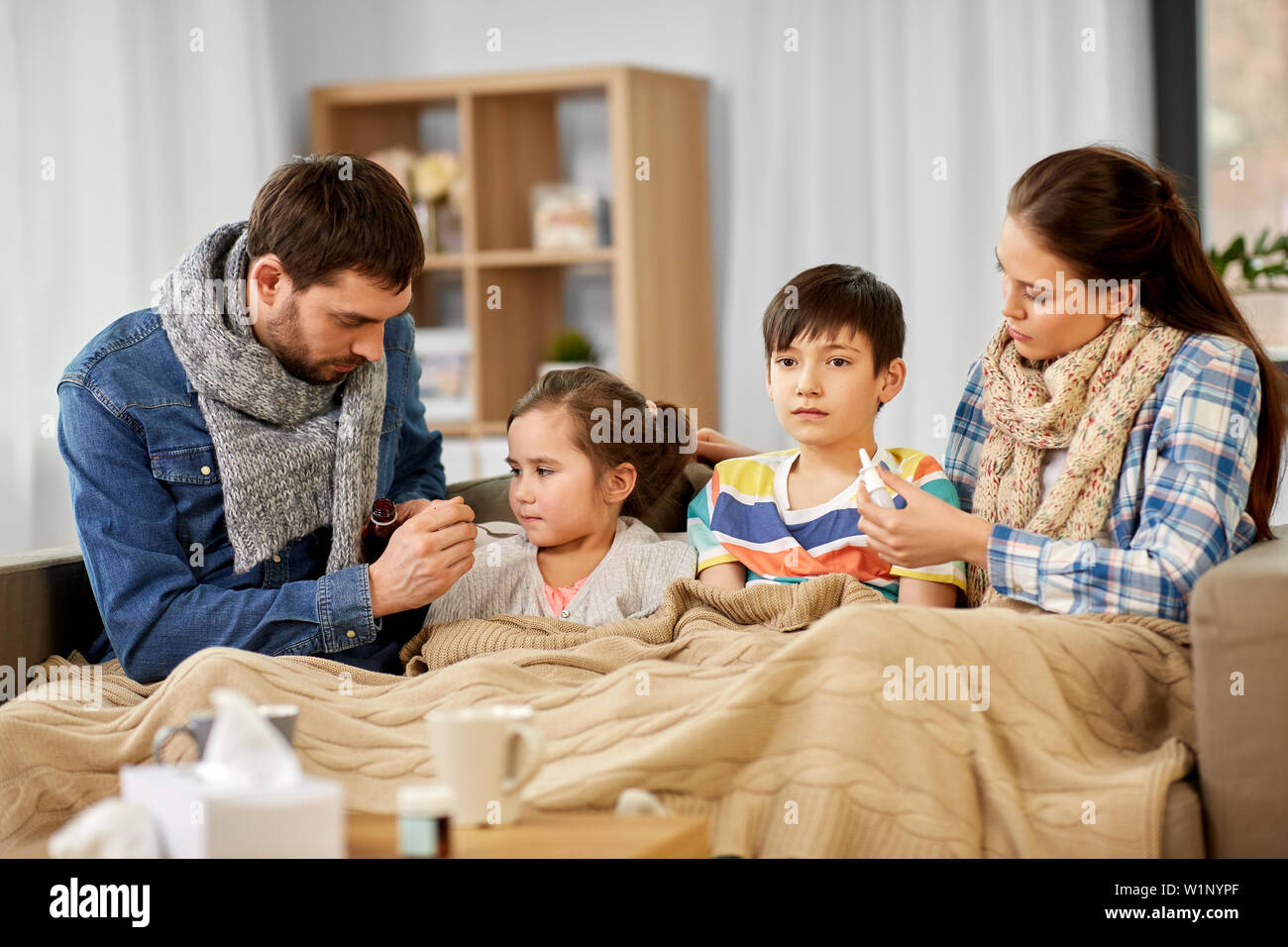 Famiglia con la medicina trattare male i bambini a casa Foto Stock