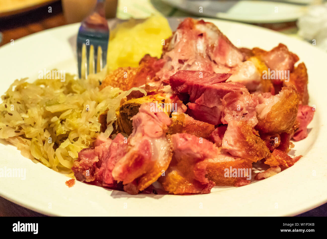 Il tedesco la carne di maiale fritto con le verdure su una piastra bianca Foto Stock