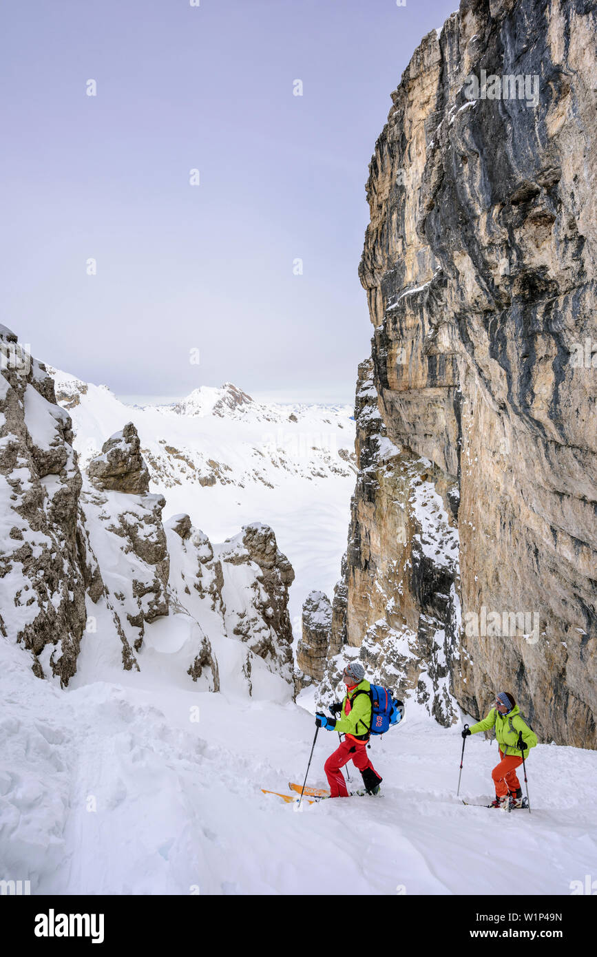 Due persone sci backcountry salendo attraverso canyon a Puezspitze, Puezspitze, parco naturale Puez-Geisler, sito patrimonio mondiale dell'UNESCO Dolomiti, FARE Foto Stock