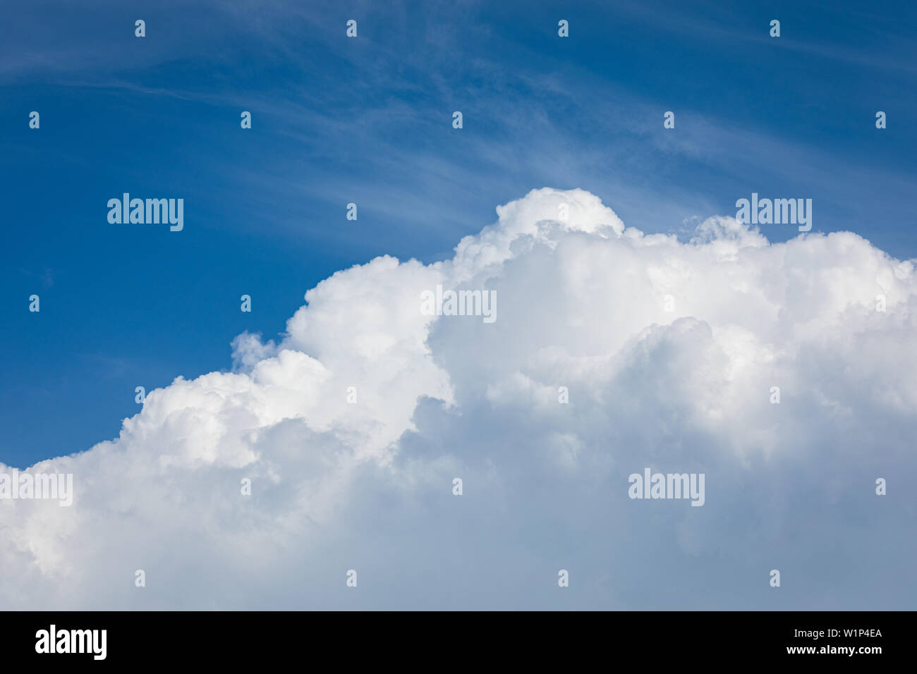 Rising storm cloud e cielo blu nella luce del sole Foto Stock