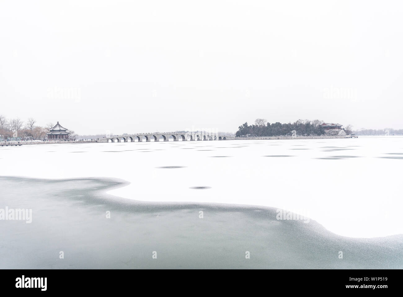 Diciassette il ponte di arco che conduce alla Nanhu Island, il nuovo palazzo d'Estate a Pechino in inverno, congelati Lago Kunming, in Cina, Asia, patrimonio mondiale dell UNESCO Foto Stock