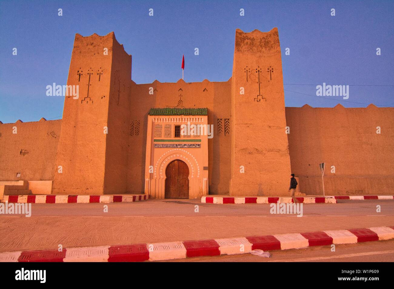 Fango-walled mura e fortezza dopo il tramonto a Rissani nella valle di Ziz, Marocco Foto Stock