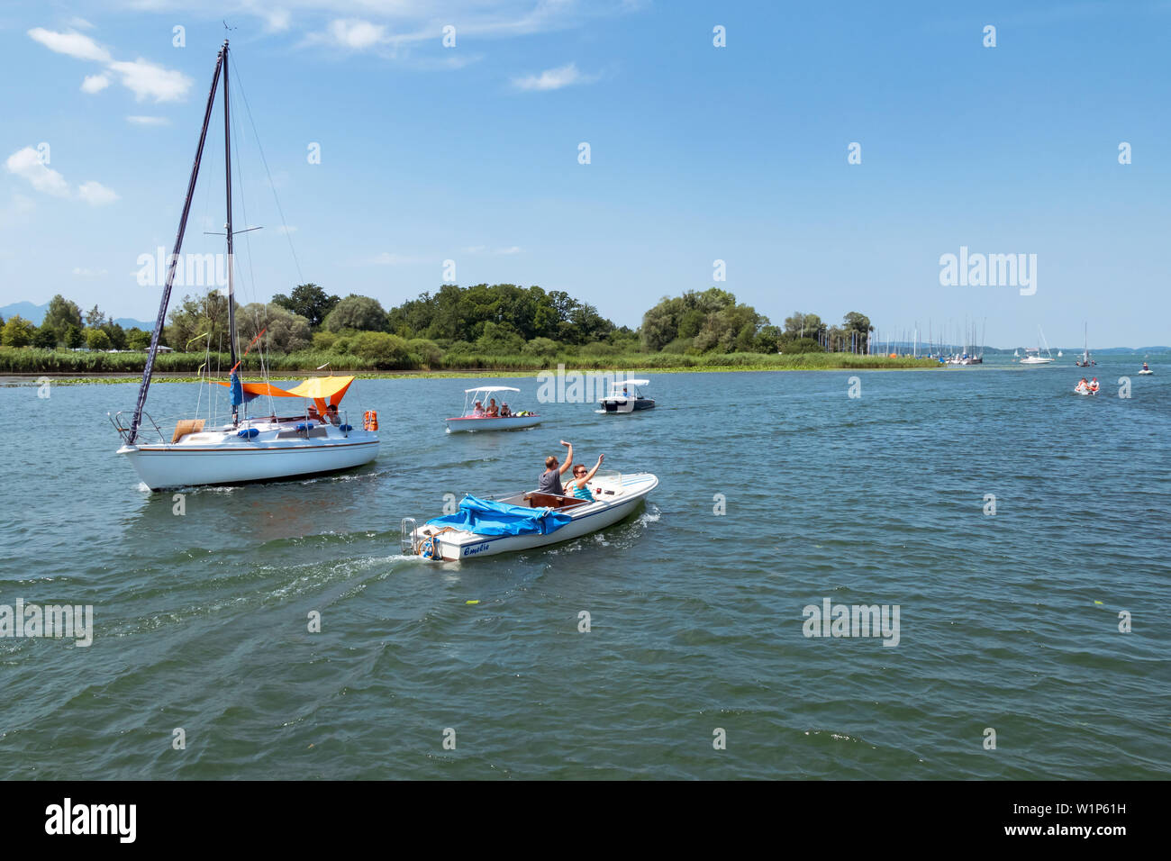 La barca a vela e barche elettriche sul Chiemsee nel campo Foto Stock
