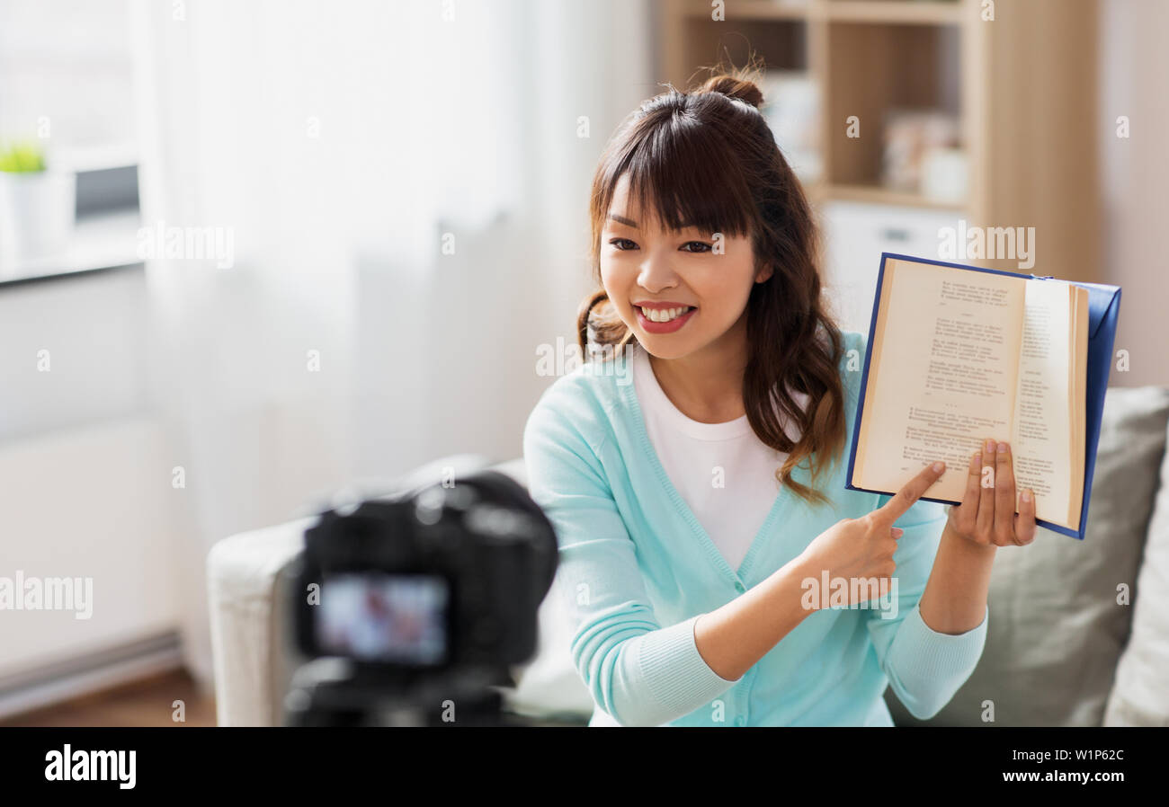 Femmina asiatica blogger rendendo video recensione del libro Foto Stock
