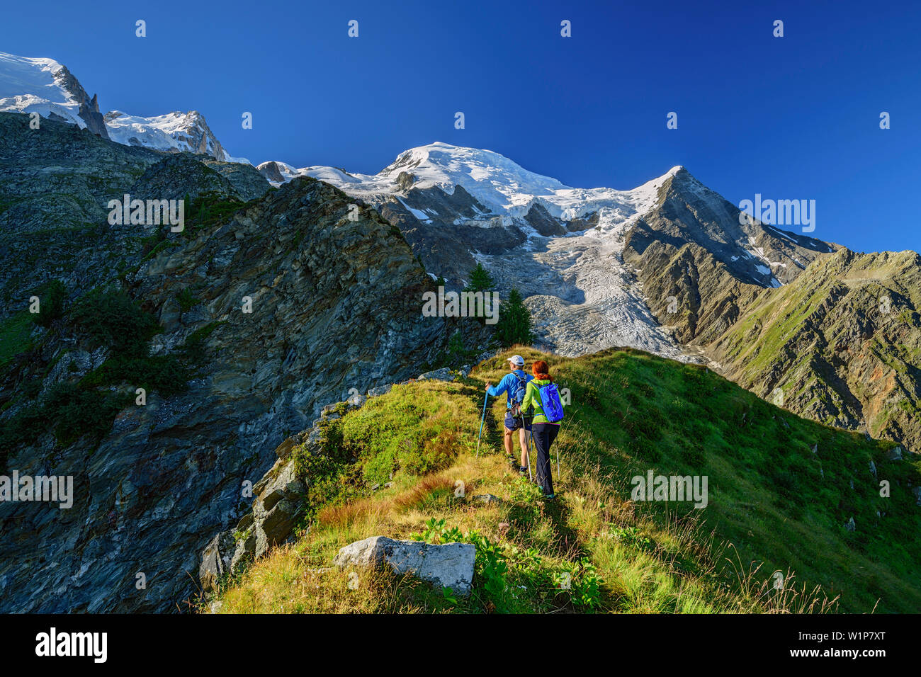 Un uomo e una donna si elevano al di sopra sottolineato torna alla piramide sul Mont Blanc in background, piramide, Mont Blanc, Grajische Alpi, alle Alpi della Savoia, Savoie Foto Stock