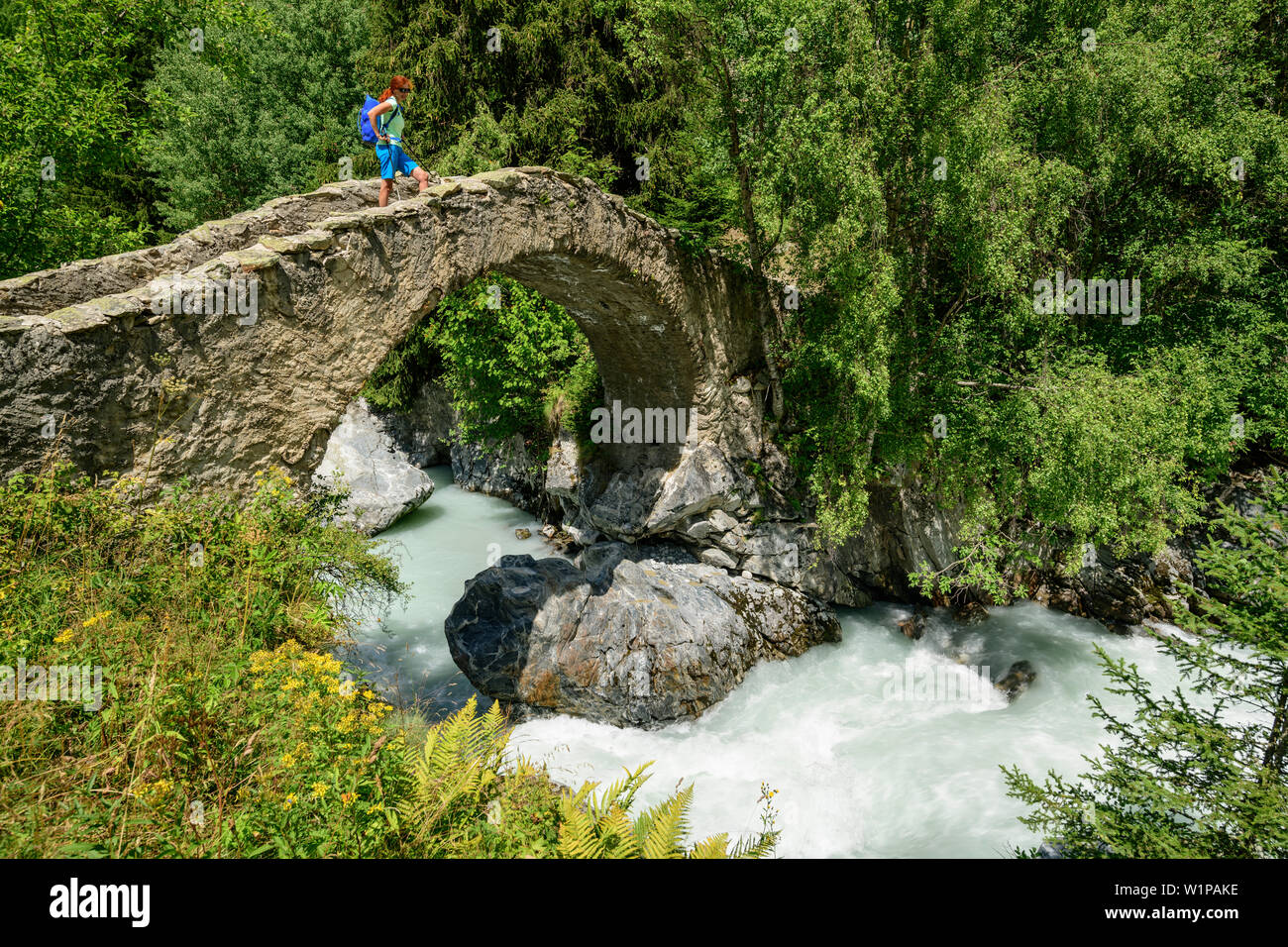 La donna va su pietra romana ponte Pont de la Raya, Rifugio de Lavey, Ecrins Parco Nazionale degli Ecrins, Dauphiné, Dauphiné, Hautes Alpes, Francia Foto Stock
