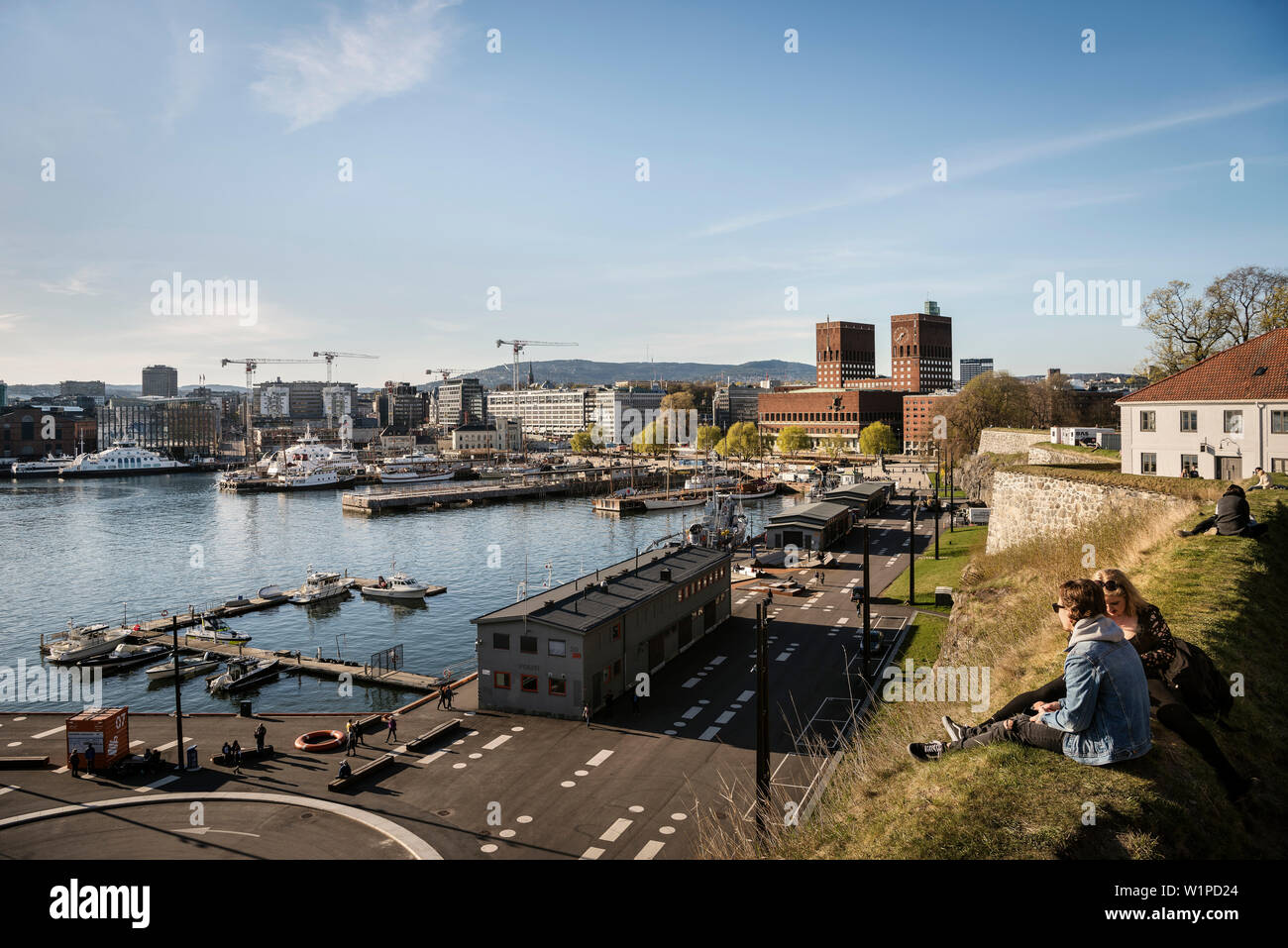 Le persone che si godono la vista da Akershus Festning al Oslofjord e Municipio di Oslo, Norvegia, Scandinavia, Europa Foto Stock
