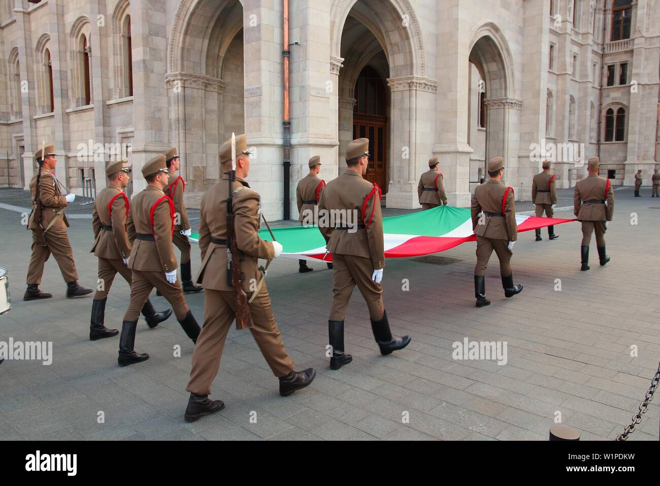 BUDAPEST, Ungheria - 19 giugno 2014: soldati eseguire la cerimonia della bandiera nella parte anteriore del parlamento ungherese di Budapest. Foto Stock