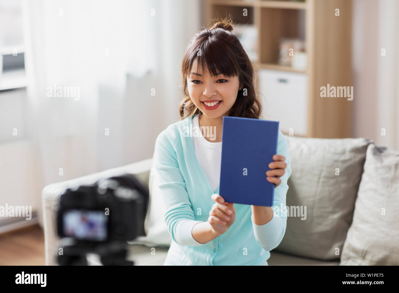 Femmina asiatica blogger rendendo video recensione del libro Foto Stock