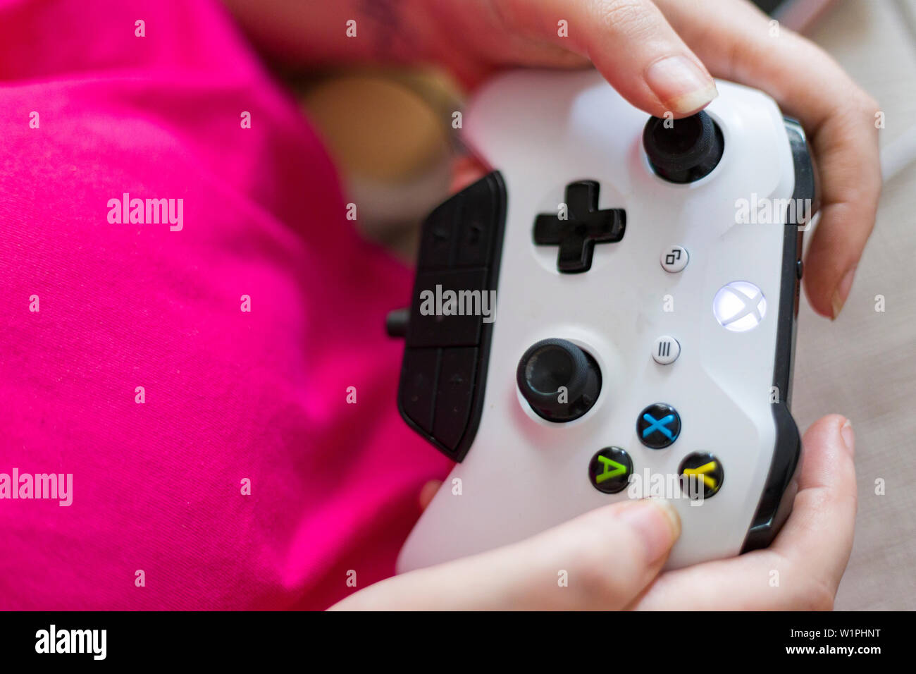 Vista ravvicinata della persona di sesso femminile di mani e giocare con il bianco Microsoft Xbox uno dei controller Foto Stock