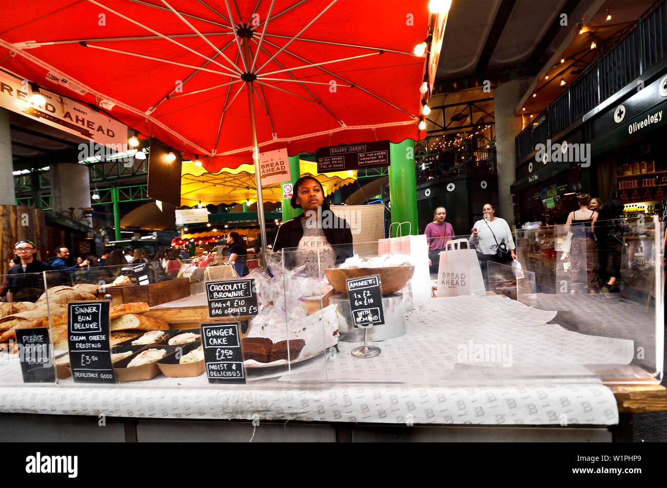 Londra, Inghilterra, Regno Unito. Borough Market, Southwark. Donna su un pane / Torta di stallo pane " Avanti " Foto Stock