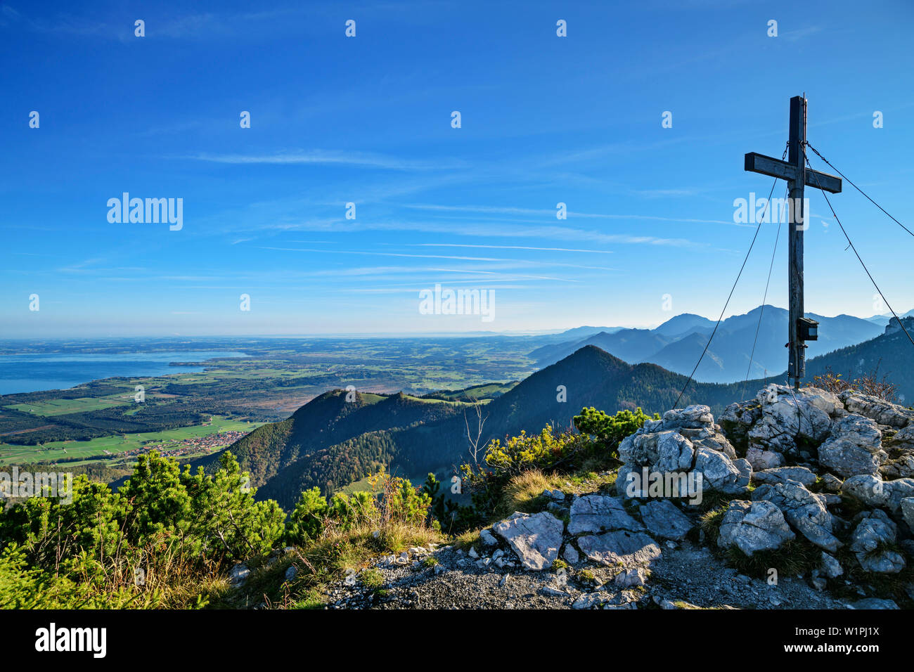 Croce di vetta del Gedererwand con il lago di Chiemsee in background, Gedererwand, Kampenwand, Chiemgau Alpi, Chiemgau, Alta Baviera, Baviera, Germania Foto Stock