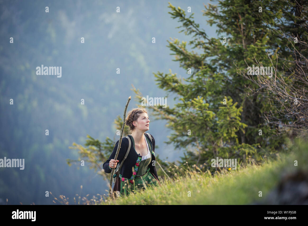 Giovane donna in costume tradizionale escursionismo sul Falkenstein nell'Allgaeu, Pfronten, Baviera, Germania Foto Stock