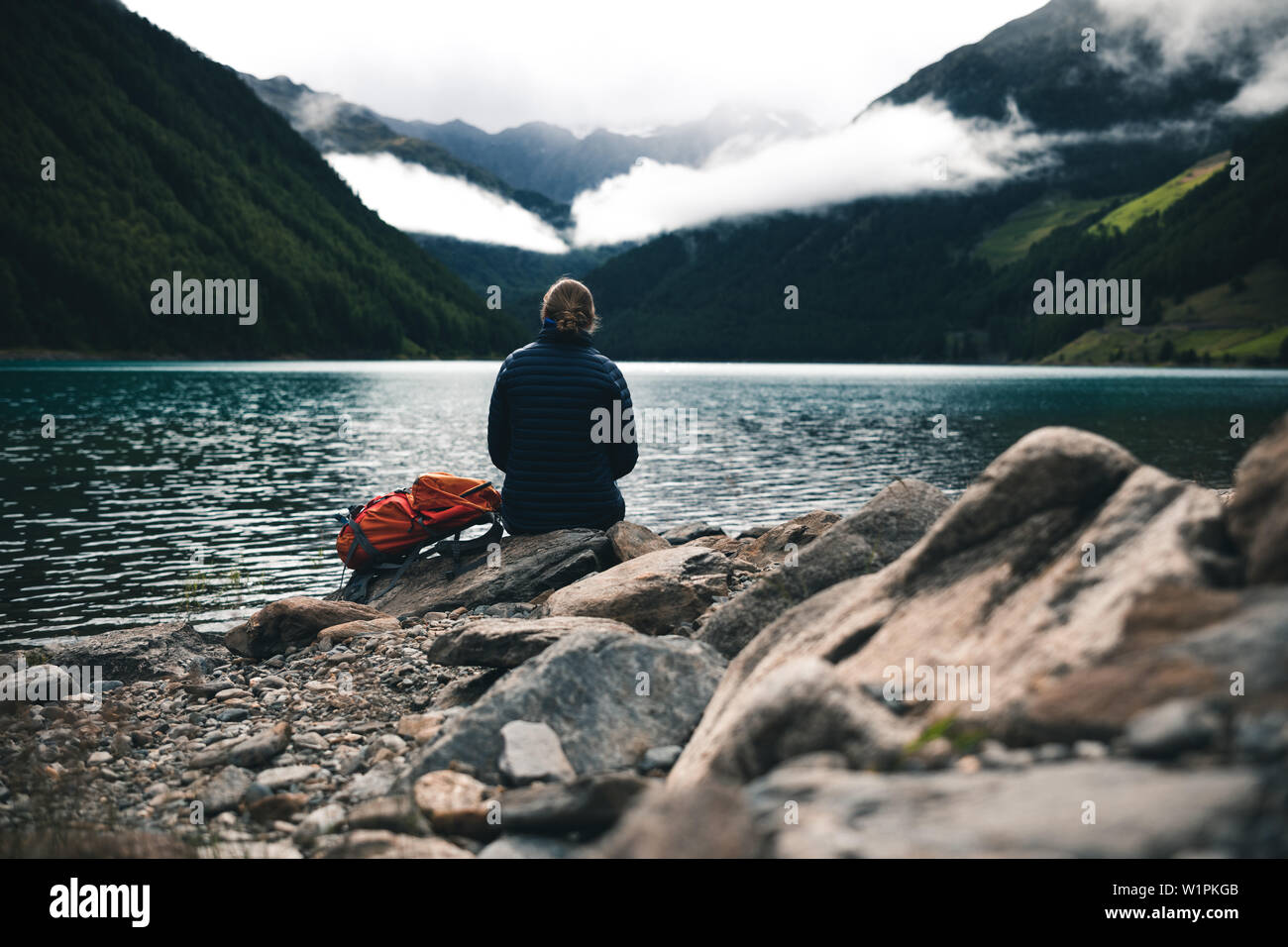 Scalatore gode di vista sul serbatoio di Vernago in misty umore, E5, Alpenüberquerung, 6a tappa, sfiato,Niederjochbach, rifugio Similaun, Val Senales, Vernago ri Foto Stock