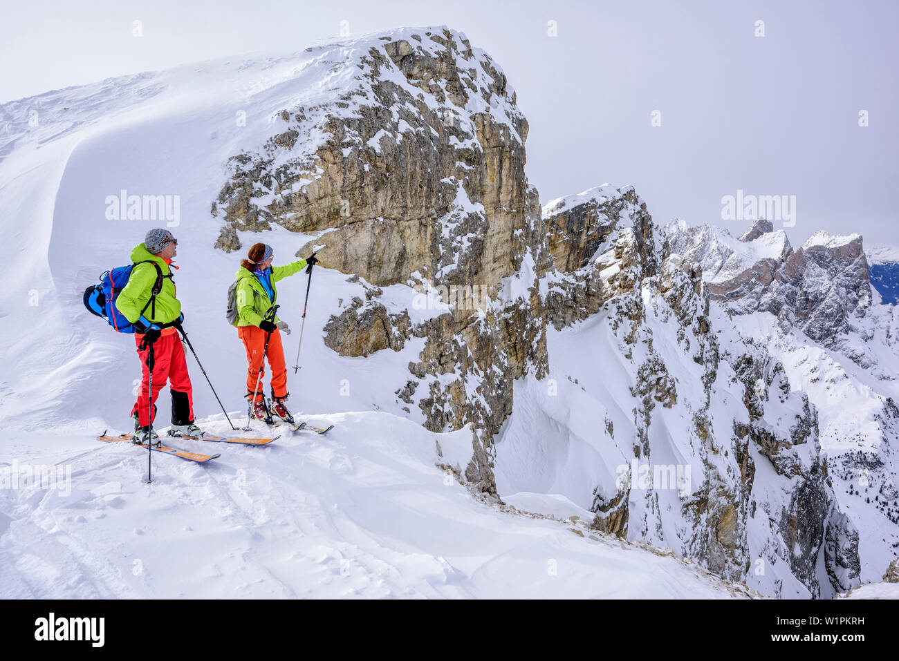 Due persone sci backcountry guardando verso Geisler gamma, da Puezspitze, parco naturale Puez-Geisler, sito patrimonio mondiale dell'UNESCO Dolomiti, Dolomi Foto Stock