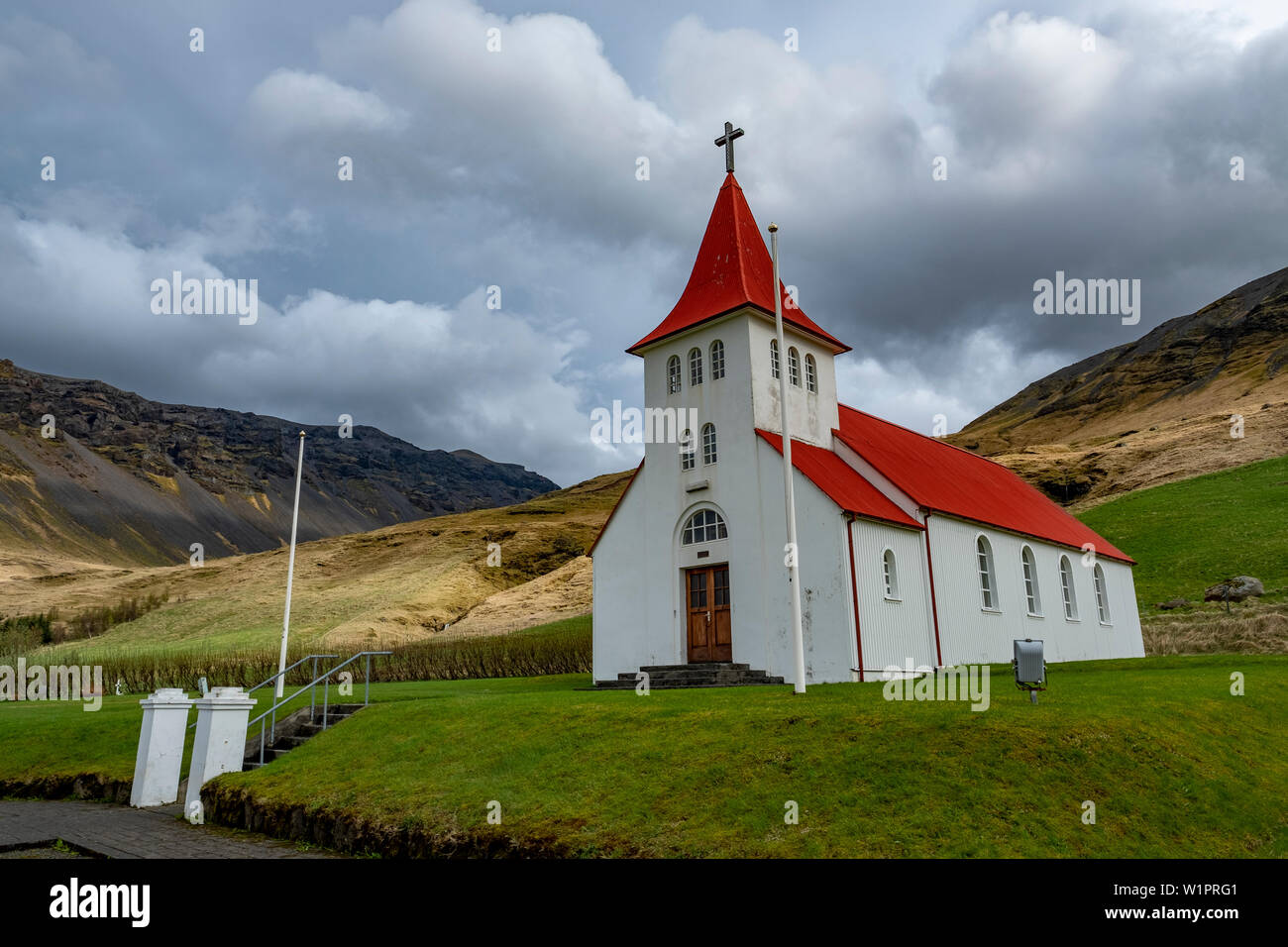 Chiesa islandese con un tetto rosso arroccato sul pendio di una collina nel sud-est dell'Islanda Foto Stock