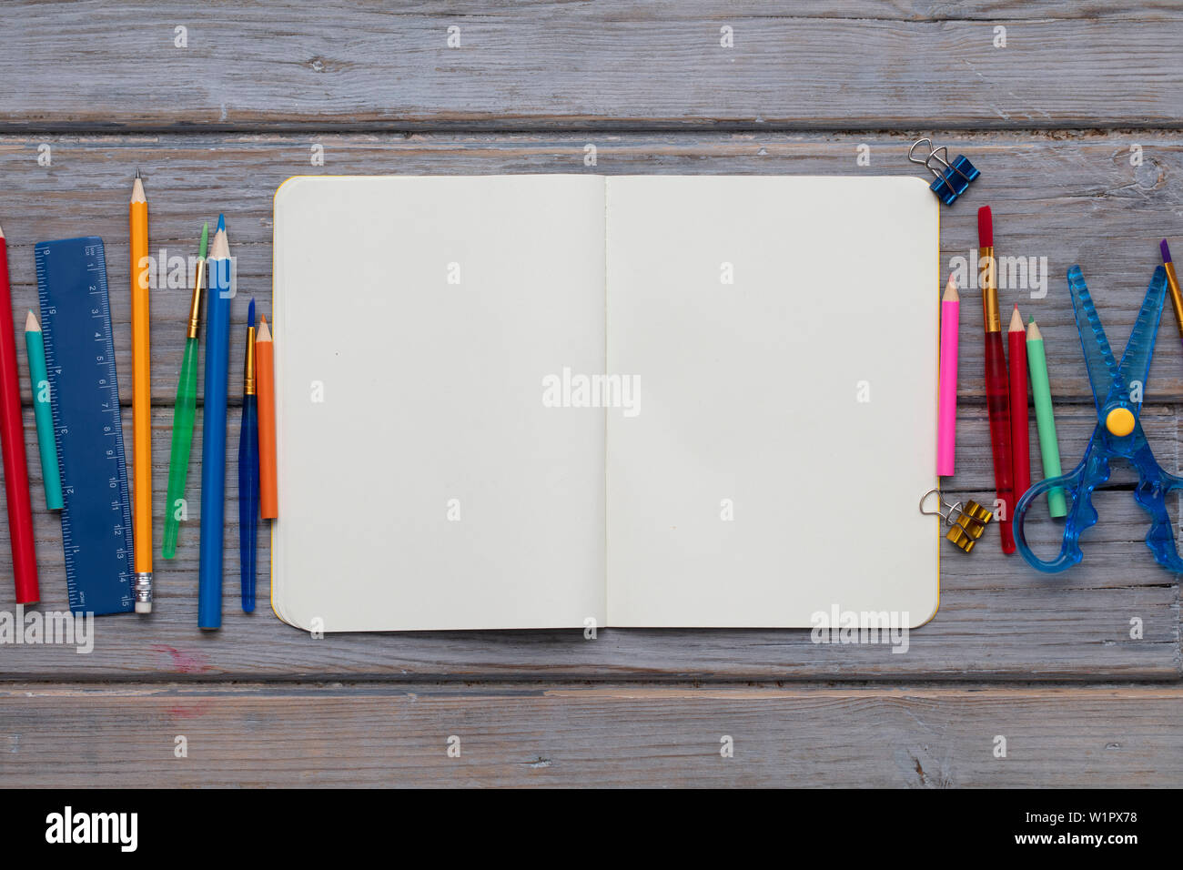 Blank notepad e arte per bambini fornisce su un sfondo di legno Foto Stock