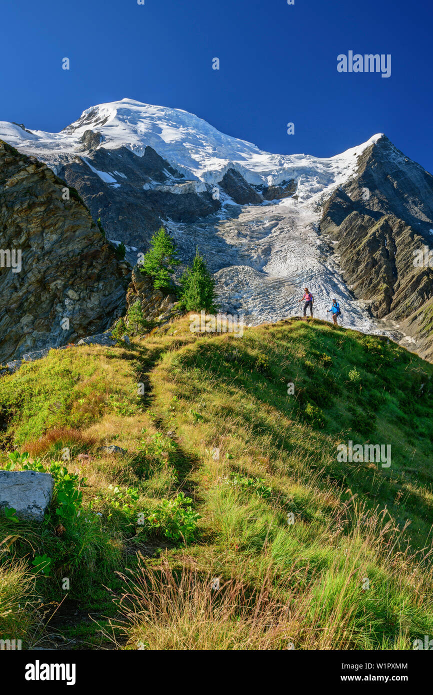 Un uomo e una donna si elevano al di sopra sottolineato torna alla piramide sul Mont Blanc in background, piramide, Mont Blanc, Grajische Alpi, alle Alpi della Savoia, Savoie Foto Stock