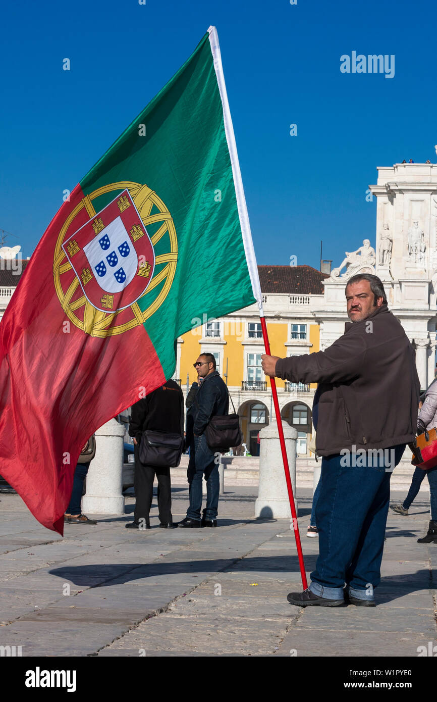Grasso patriottica uomo con bandiera portoghese, Cais das Colunas, Praça do Comércio, Lisbona, Portogallo Foto Stock