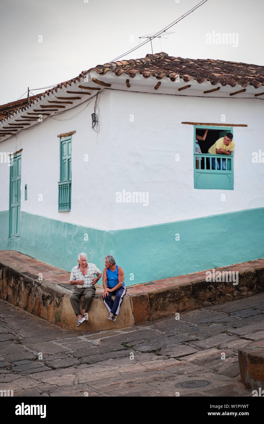 Traino di vecchi uomini seduti sul marciapiede e avere una conversazione, Barichara, Departmento Santander, Colombia, Southamerica Foto Stock