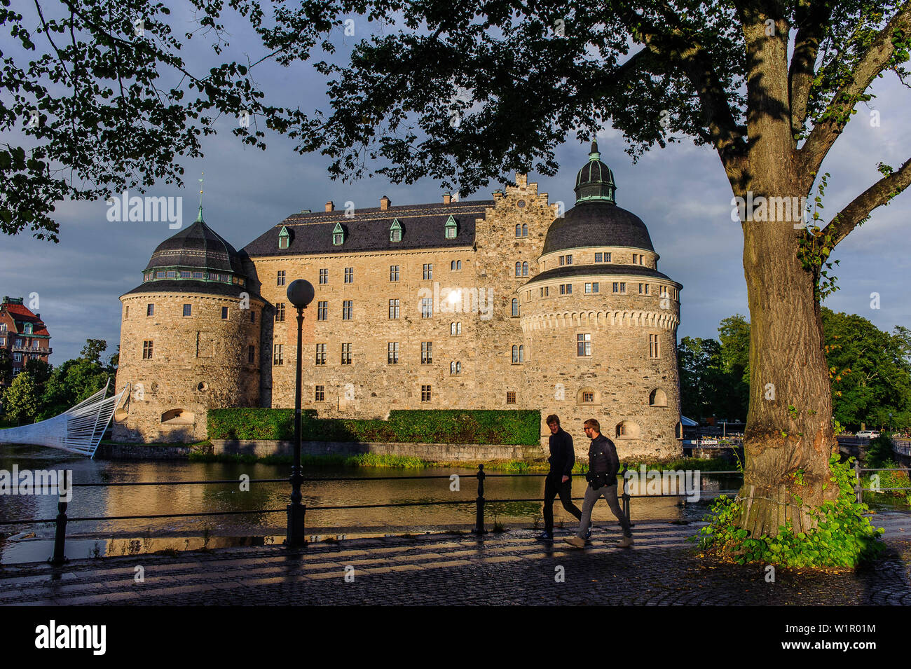 Giovani uomini andare per una passeggiata di fronte al castello di Oerebro, Svezia Foto Stock