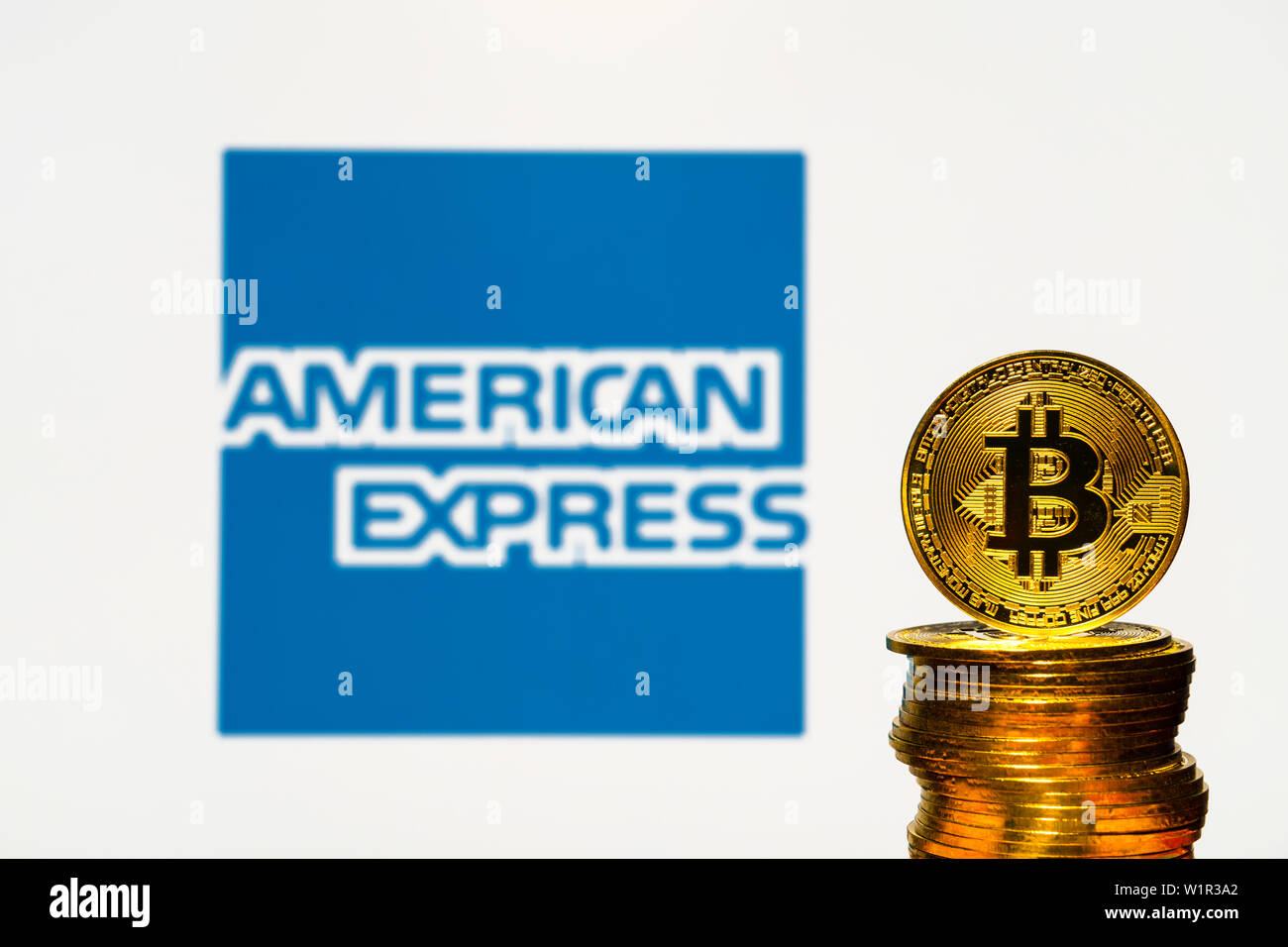 Oro Bitcoin monete con la American Express logo su sfondo dello schermo. Un nuovo tipo di business finance concetto. Foto Stock