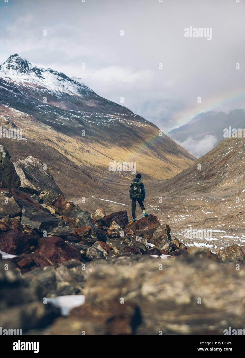 Scalatore gode di vista di arcobaleno e panorama di montagna, E5, Alpenüberquerung, 6a tappa, sfiato,Niederjochbach, rifugio Similaun, Val Senales, Vernago reservoi Foto Stock